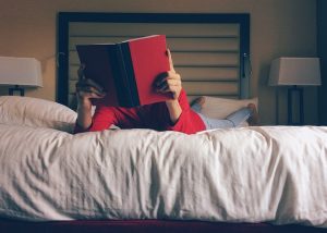 child reading on a clean hotel bed